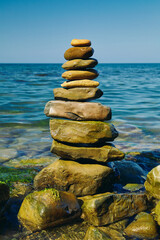 Fototapeta na wymiar Stone pyramid on a pebble beach. Symbolizes stability and harmony