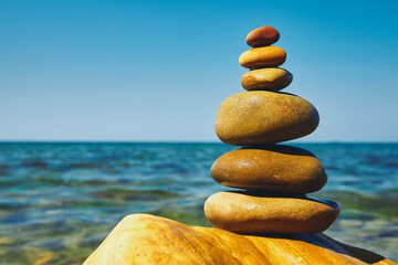 Stone pyramid on a pebble beach. Symbolizes stability and harmony