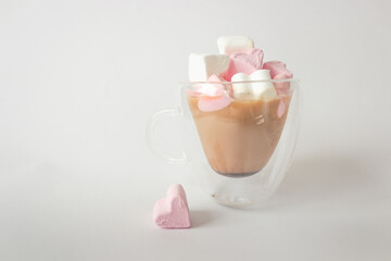 Glass double bottom cup of coffee with marshmallow in heart form. Isolated on white background.