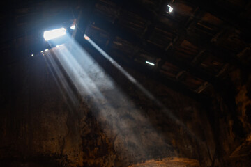 sun rays enter through the broken roof in house.