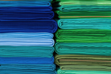 Layers of colorful fabric, colorful background. Pile of bright rolls of fabric.