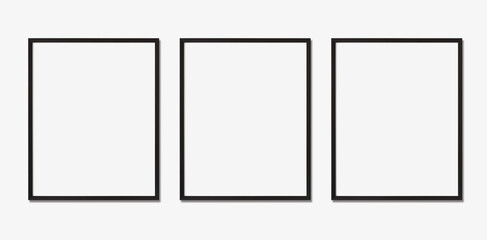 Photo frame mockup. Set of three vertical black frames on white wall. Template for artwork, painting, photo or poster