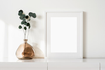 Blank picture frame mockup on white wall. Template for painting or poster. White living room interior design. View of modern style interior with artwork mock-up