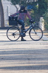 Fototapeta premium 自転車でフードデリバリーをする東京港区南青山2丁目の青山霊園での風景