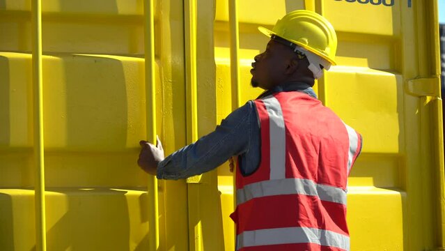 african harbor worker checking list quality and closing  Containers box together at warehouse logistic in Cargo. teamwork of import export