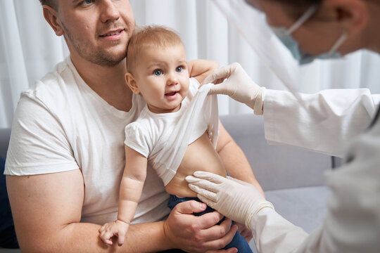 Doctor Lifting Up Child Shirt And Touching Its Belly