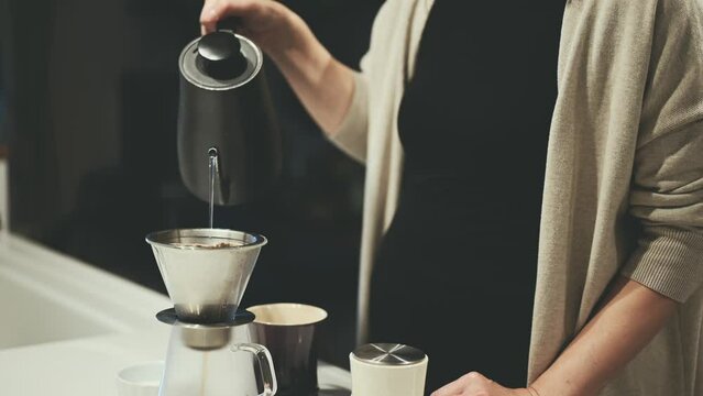 ドリップコーヒーを淹れる女性