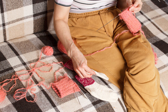 The knitting project is under implementation. A woman knits wool socks