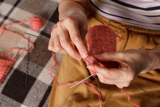 The knitting project is under implementation. A woman knits wool socks