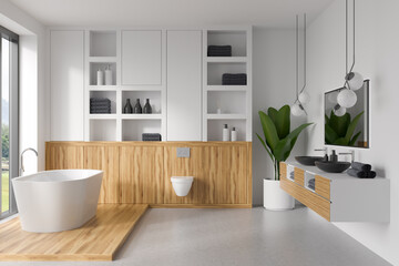 Light bathroom interior with bathtub, toilet, sink with window