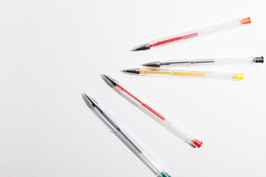 multi-colored gel pens for writing on a white background. the concept of office stationery
