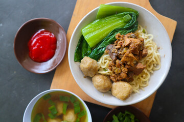 mie ayam or chicken noodle  with meatball served on small bowl
