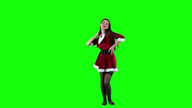 Beautiful lady dancing in front of the green screen in Christmas costume
