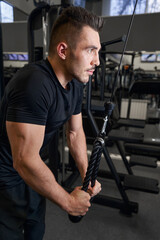 Obraz na płótnie Canvas Strong man doing physical training in the gym