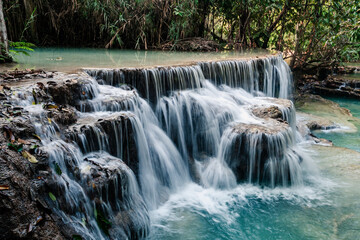 Fototapeta na wymiar Amazing turquoise water of Kuang Si waterfall in tropical rain forest. Laos