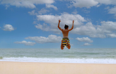 Freedom lifestyle of young man feeling a happiness man jumping on beach in summer tropical  background