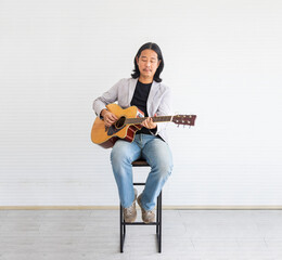 Asian artist singing song and playing acoustic guitar on white background for live acoustic concert...