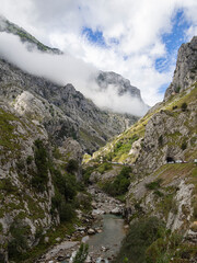 Vistas del río y de las altas montañas con el cielo con nubes  de la ruta del Cares desde Poncebos en Asturias, para senderistas amantes de la naturaleza y excursiones de montaña, en el verano de 2020