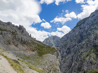 Fototapeta na wymiar Vistas de un camino en el acantilado de la montaña del Cares desde Poncebos en Asturias, para senderistas amantes de la naturaleza y excursiones , en el verano de 2020
