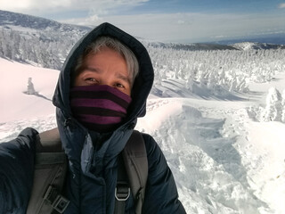 Young Man Smile Camera Taking Selfie Photo on top viewpoint mountain Zao, Yamagata. with snow monster background.