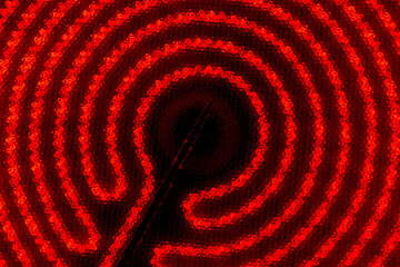 The colorful and vivid red and black monochrome background of hob of cooktop. Glowing stove spiral on the black background
