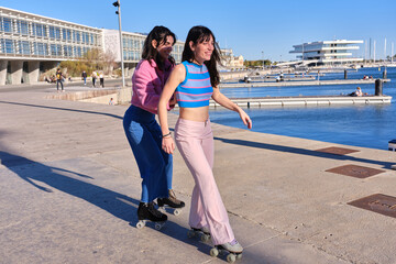 Two friends skating with classic skates in a promenade