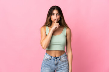 Young caucasian woman isolated on pink background showing a sign of silence gesture putting finger in mouth