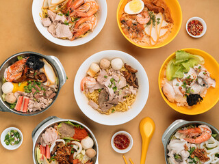 chinese seafood table with Tom Yum, Xiao Wan, Sliced Fish, Porridge, Bee Hoon, Black Soya Sauce, in a bowl with soup, chili sauce, spring onion top view on wooden table chinese seafood noodle table
