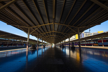 Fototapeta premium Perspective railway station platform under a steel frame roof