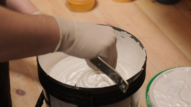 A worker kneads the paint for painting the walls