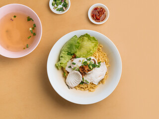 vietnamese food Sliced Fish Noodle in a bowl with soup, chili sauce and spring onion top view on wooden table