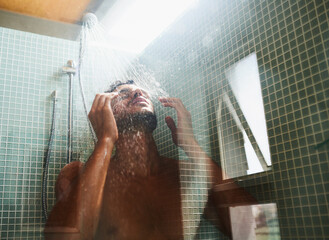 Theres nothing like a rejuvenating shower. Cropped shot of a handsome young man having a refreshing...