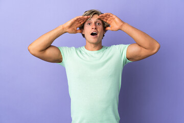 English man over isolated purple background with surprise expression