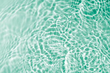 Soft focus lite green blue gray cosmetic moisturizer floral water, micellar toner, or emulsion abstract background. Reflections of  scattered sun texture.