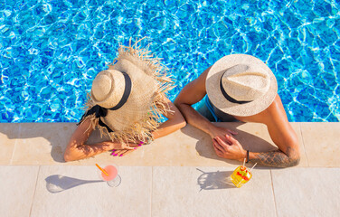 Couple enjoying drinks by the pool, overhead view