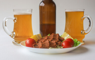 Cig kofte / Turkish Food and beer bottle in the background, beers in glasses.