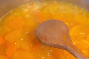 a wooden cooking spoon over a pumpkin stew