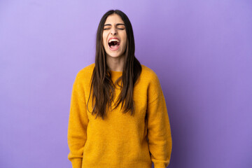 Young caucasian woman isolated on purple background shouting to the front with mouth wide open