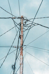Street electric pole with many electrical wires and fiber optic cables