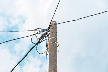 Street electric pole with many electrical wires and fiber optic cables