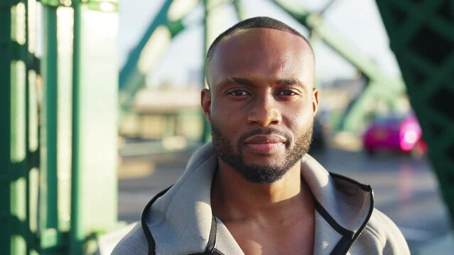 Close up of Confidence African man face in sportswear jogging exercise on the bridge in the city with street lights at night. Strong male athlete enjoy outdoor activity sport training running workout