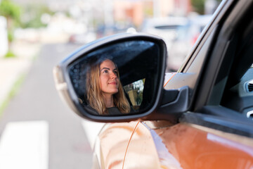 woman driving an electric car, mirror view