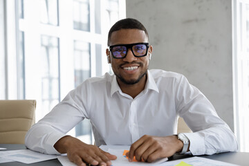 Front view smiling young handsome African American male executive manager leader in eyeglasses...