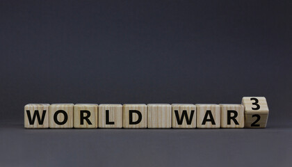WW3 world war 3 symbol. Turned the wooden cube and changed the concept word World War 2 to World War 3. Beautiful grey table grey background, copy space. Business WW3 world war 3 concept.