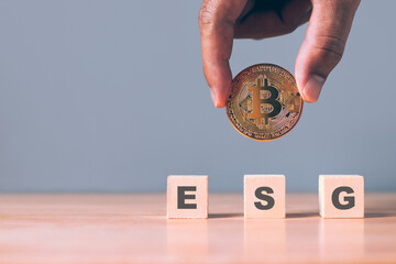 Environmental, Social and Governance. Renewable Cryptocurrency Mining. gold bitcoin and E-S-G letters on wood block.