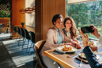 Diverse women in cafe taking photo
