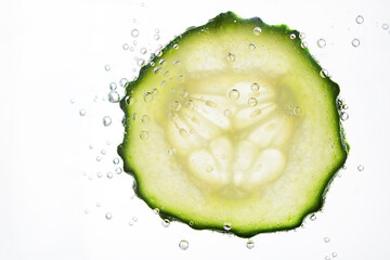 Sliced cucumber with water bubbles on white background. Skin moisturizing cosmetics concept....