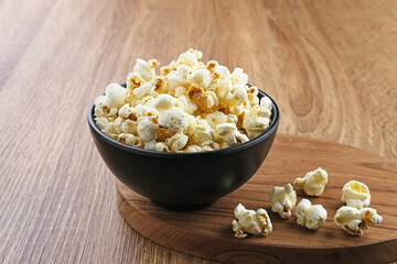 Popcorn, a kind of savory snack from corn seed. Served in a small bowl, selected focus.
