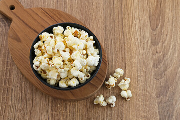 Fototapeta na wymiar Popcorn, a kind of savory snack from corn seed. Served in a small bowl, selected focus. 