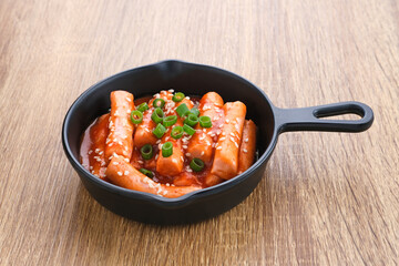 Tteokbokki or Topokki , stir fried rice cake stick, popular Korean street food with spicy gochujang sauce and sesame seed. 
